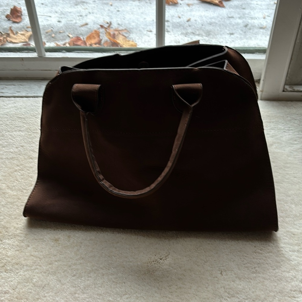 Brand new bag rich brown in color with gold buckles on side and magnetic closure